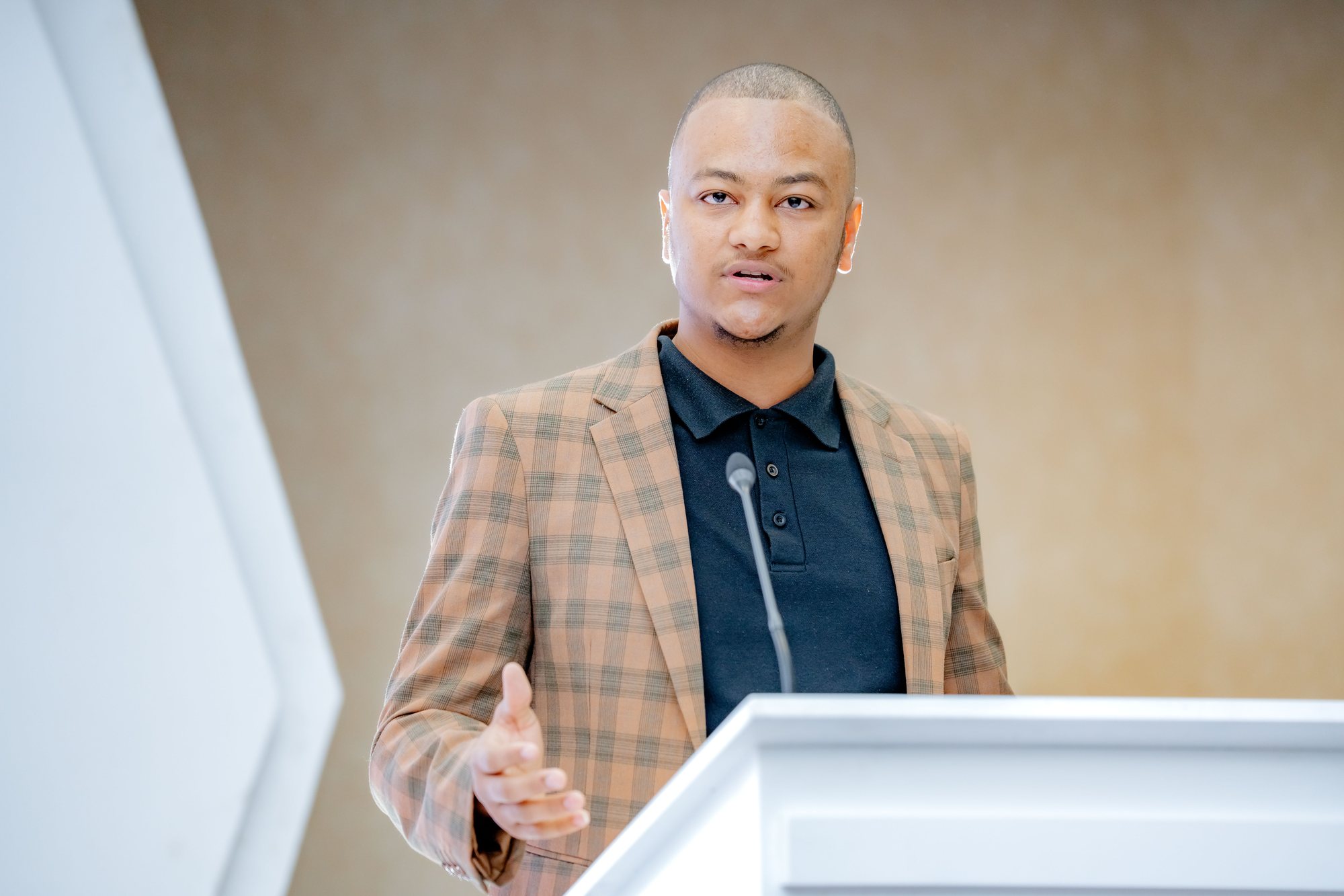 Maverick Kabelo gesturing while speaking at the lectern