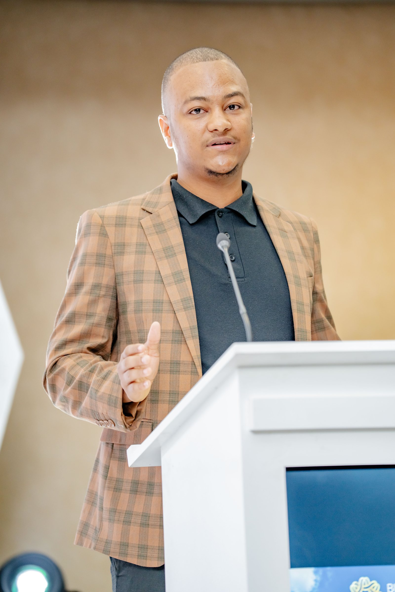 Maverick Kabelo gesturing while speaking at the lectern