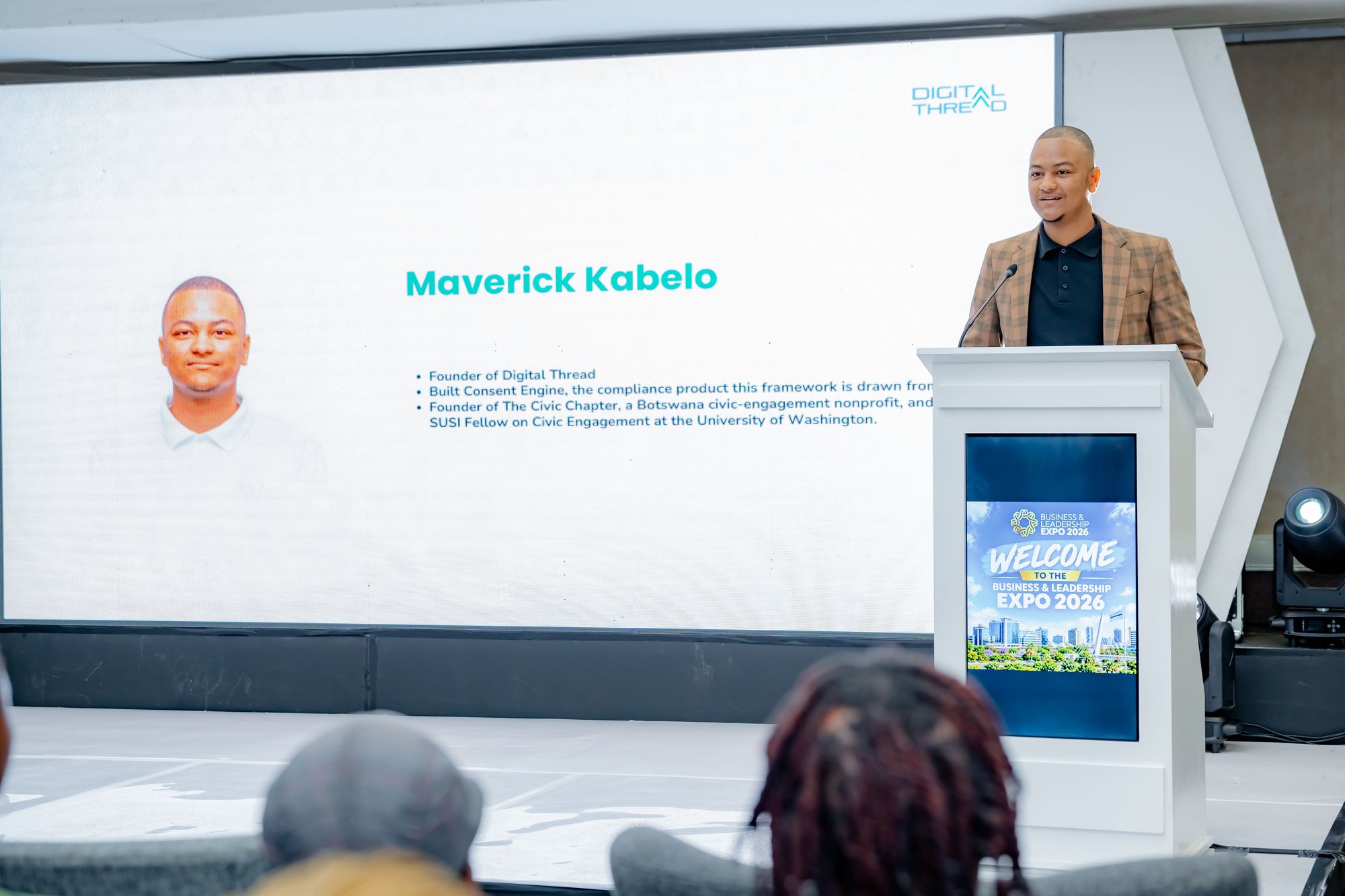 Maverick Kabelo at the lectern with his title slide displayed on screen