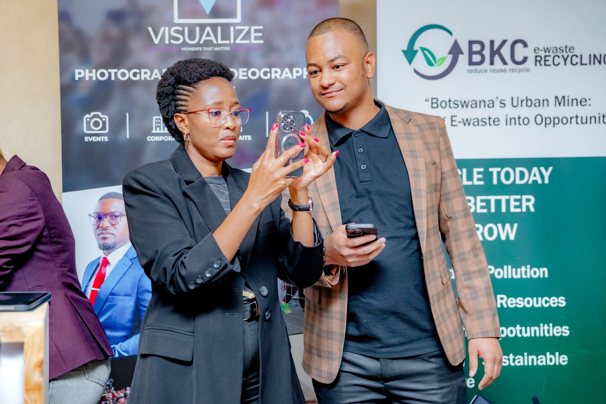 Maverick Kabelo being shown something on a phone by an attendee at the expo