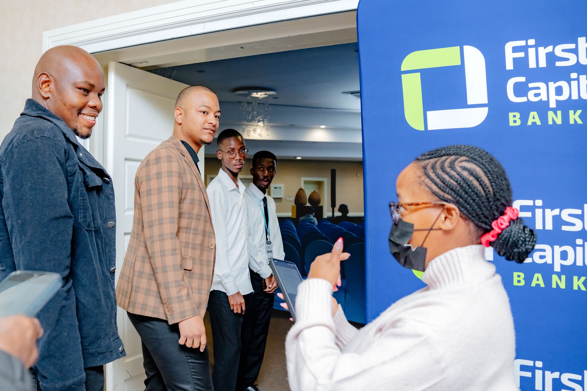 Maverick Kabelo talking with an attendee near the First Capital Bank stand