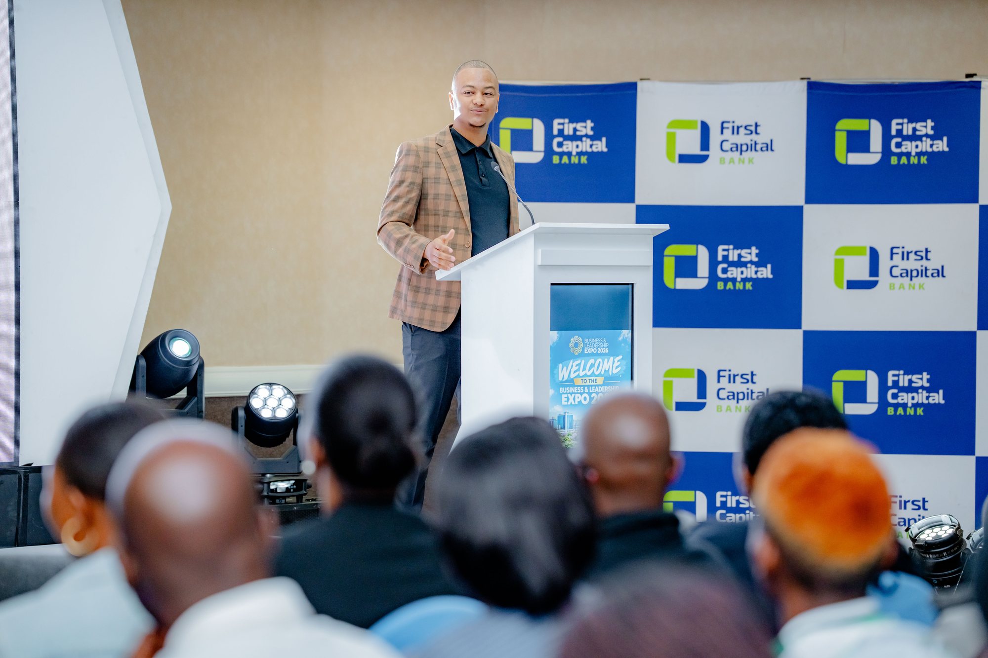 Maverick Kabelo speaking at the lectern with the First Capital Bank backdrop